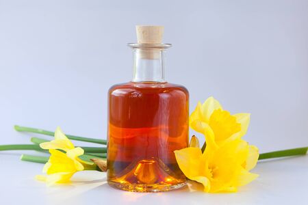 Essence of flowers on a table in a beautiful glass jarの写真素材