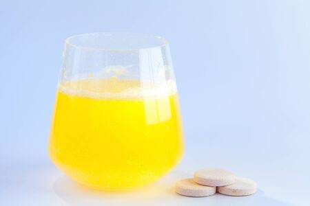glass cup on a White background with effervescent vitaminsの写真素材