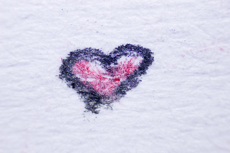 painted black marker heart under a microscopeの写真素材