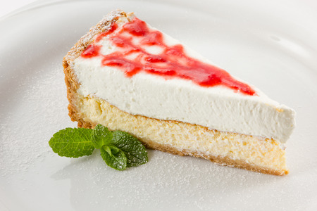 cheesecake with berry glaze and mint
sprinkled with powdered sugar on a plateの写真素材