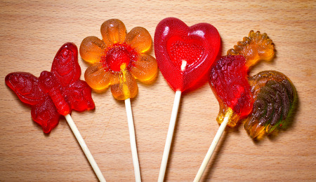 colored candy on a stick in the form of a cockerel heart and flowersの写真素材