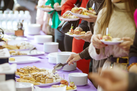 The hands of people taking food at the conference.の写真素材