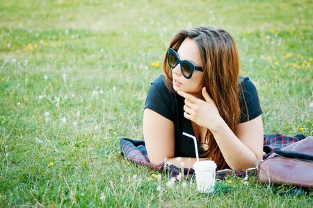 beautiful girl student lies on the grassの写真素材