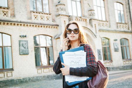 student near university building after writing an examの写真素材
