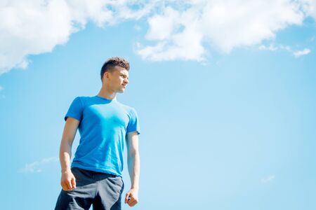 young and cheerful athlete by the river under the bright sunの写真素材