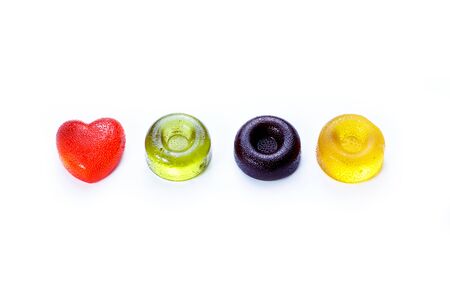 Multicolored round and heart shaped lollipops lying on a white background