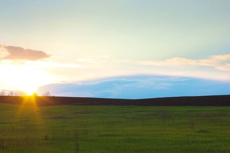 spring field plowing, sunset rays of the sun