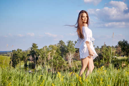 girl in a white dress walks in the fieldの写真素材