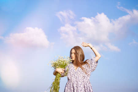 young beautiful girl with a bouquet of flowers in nature