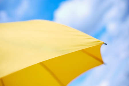 bright yellow umbrella against a clear skyの写真素材