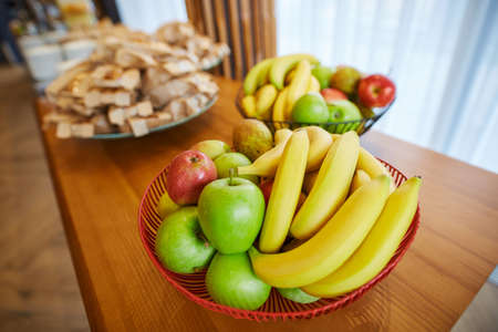 bananas, apples, pears and other treats on the tableの写真素材