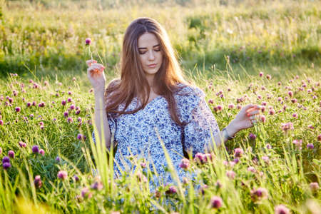 young beautiful girl with a bouquet of flowers in natureの写真素材