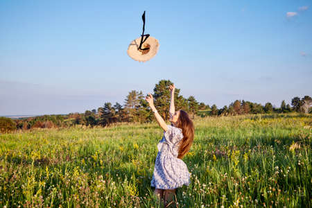 beautiful young girl with a straw hat in natureの写真素材