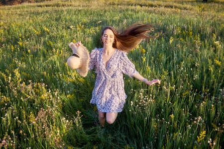 beautiful young girl with a straw hat in natureの写真素材