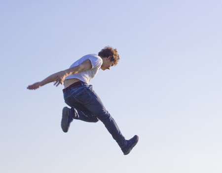 teenager in white t-shirt bouncing high upの写真素材