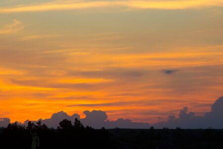 clouds above the horizon lit by the setting sunの写真素材