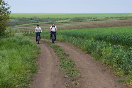 father and son on a bike ride on a country roadの写真素材