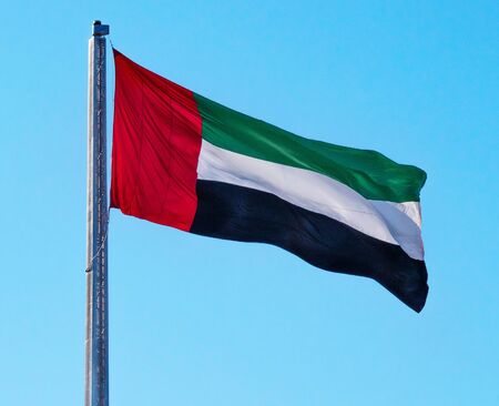 UAE National Flag of United Arab Emirates Waving on Sunny Blue Sky Clean Background