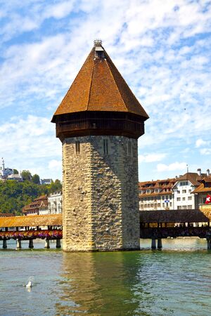 The Chapel Bridge (Kapellbrücke) is a covered wooden footbridge spanning diagonally across the Reuss River in the city of Lucerne in central Switzerland.の写真素材