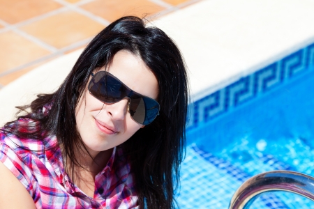 Young Happy Casual Woman with Sunglasses in the Swimming Poolの写真素材
