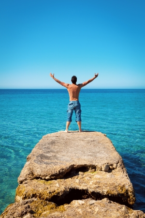 Freedom Man with Arms Wide Open in on Blue Tropical Seaの写真素材