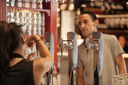 MADRID, SPAIN - AUGUST 12  Tourist ordering a beer in the famous San Miguel Market, Madrid  Built in 1913, is now one of the best places to enjoy the spanish gastronomy, on August 12, 2013 in Madrid のeditorial素材