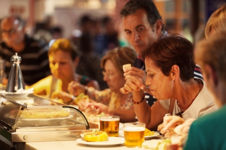 Madrid, Spain - August 12, 2013: Tourists eating tapas the famous San Miguel Market, Madrid. The market wants to be part of the agenda of Madrid events doing different activities related to leisure and culture, helping to revitalize the old capital.のeditorial素材