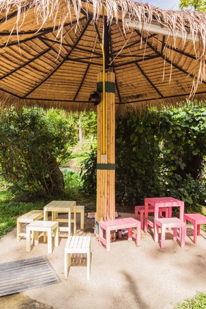 Creative thatched umbrellas with bamboo post in tropical gardenの写真素材