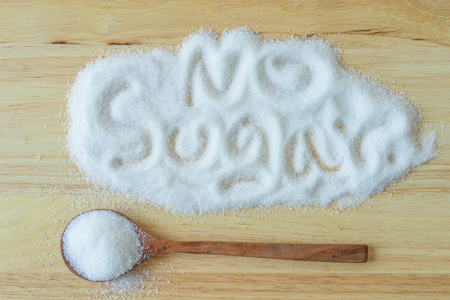 Inscription sugar made into pile of white granulated sugar on wooden  background.の写真素材