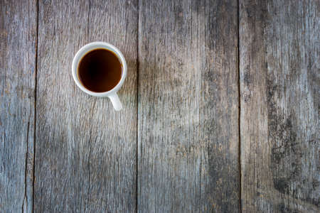 Black coffee in white Ceramic Cup on old wooden table.の写真素材