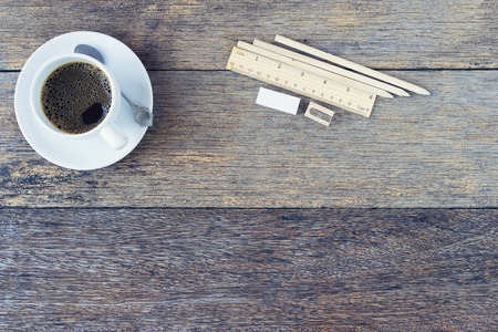Black coffee in white Ceramic Cup and pencils on old wooden table.の写真素材