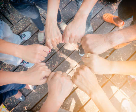 Business teamwork hands together joining group of people in circle with sun ray light and lens flare. - Concepts collaborate team and projects process to success.の写真素材