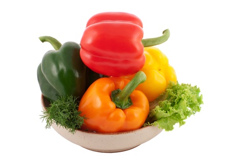 Four multicoloured bell peppers in a bowl isolated on whiteの写真素材