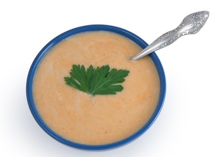Bowl of cream soup with spoonの写真素材