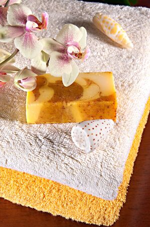 Handmade soap, orchid and shells on the towelsの写真素材
