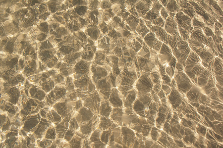 A background of sun and shadows on sandy ocean floorの写真素材
