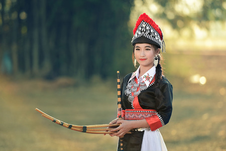 Tribal Asian woman wearing traditional dress texting smartphone.のeditorial素材