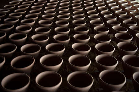 A narrow depth-of-field, blurred background and a large traditional indigenous pottery jar sits side-by-side in an Asian stone mortar pottery.の写真素材