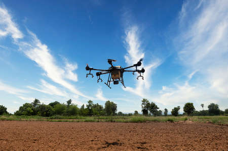 Farmers use agricultural drones to fly to spray fertilizer in rice fields. Drones, Agricultural,...
