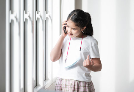 Child checking social media while holding a smartphone at home. Latin woman smiling using mobile...