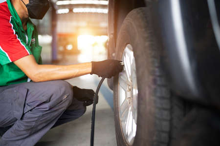 Professional service technicians in repair centers. Inflate tires at car service.の写真素材