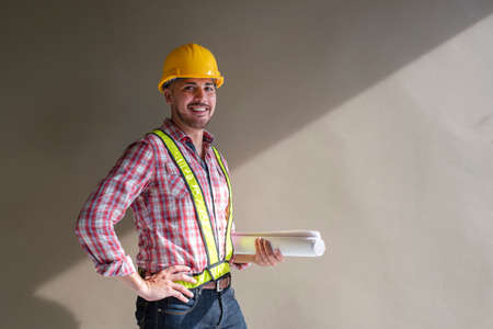 Architect studying room plan Serious civil engineer working on construction site documentation.