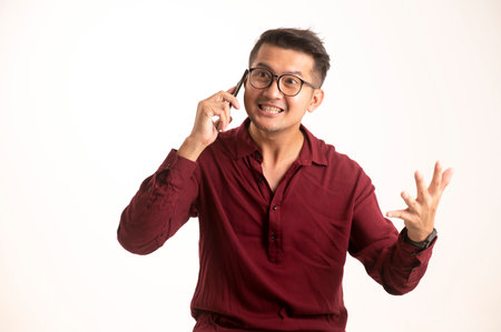 Smart Asian man using smartphone in studio background, handsome young Asian man smiling happily in formal shirt. using a smartphone to exchange or chatの写真素材
