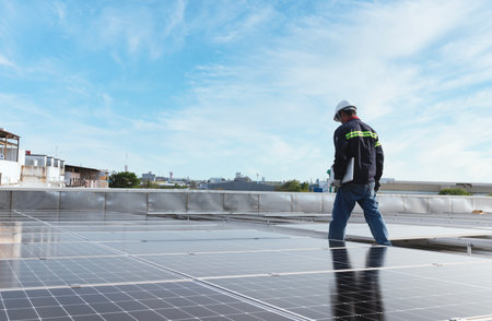 technician inspecting solar panels on factory roof Check and maintain the solar panel roof A team of...