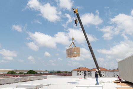 Industrial crane working and lifting power generator under sunlight and blue sky, heavy equipment...