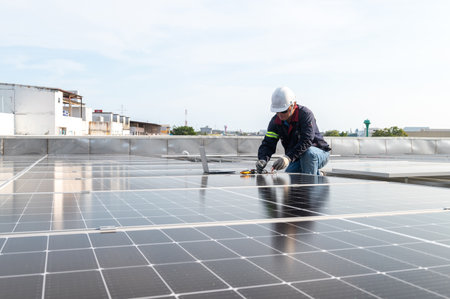 Engineer working to inspect equipment in rooftop solar power plant, solar panel maintenance installation viewの写真素材
