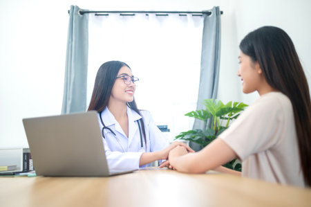 Asian young woman suffering from flu visiting professional doctor for sick problem consultation in clinic officeの写真素材