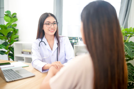 Asian young woman suffering from flu visiting professional doctor for sick problem consultation in clinic officeの写真素材