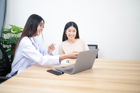 Asian young woman suffering from flu visiting professional doctor for sick problem consultation in clinic officeの写真素材