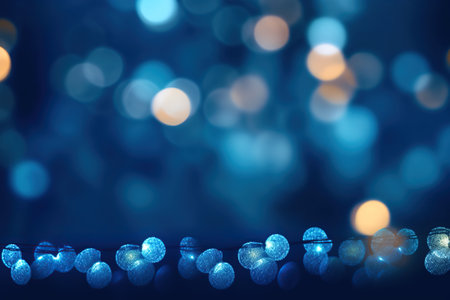 A warm golden Christmas garland glows over a dark bokeh background with a glitter overlay.の素材